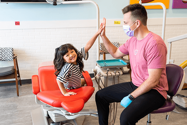 pediatric patient at Grin Pediatric Dentistry and Orthodontics high fiving doctor